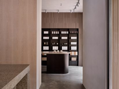 Back steel shelving displaying teas behind matching counter in interior of Basao Tea store