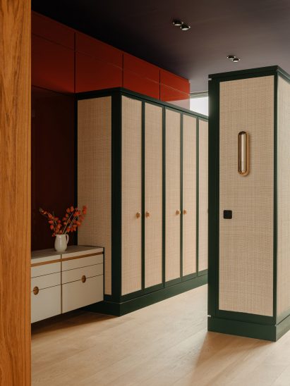 Bespoke cabinetry with cane fronts and dark green wooden frames in The Village apartment