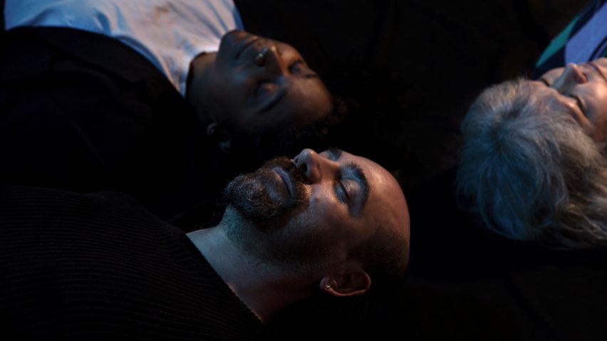 Three people lying down next to each other
