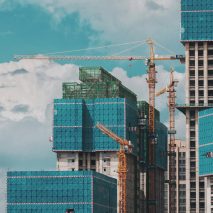 Orange crane next to buildings under construction used to illustrate stories about embodied carbon bill by Duncan Baker