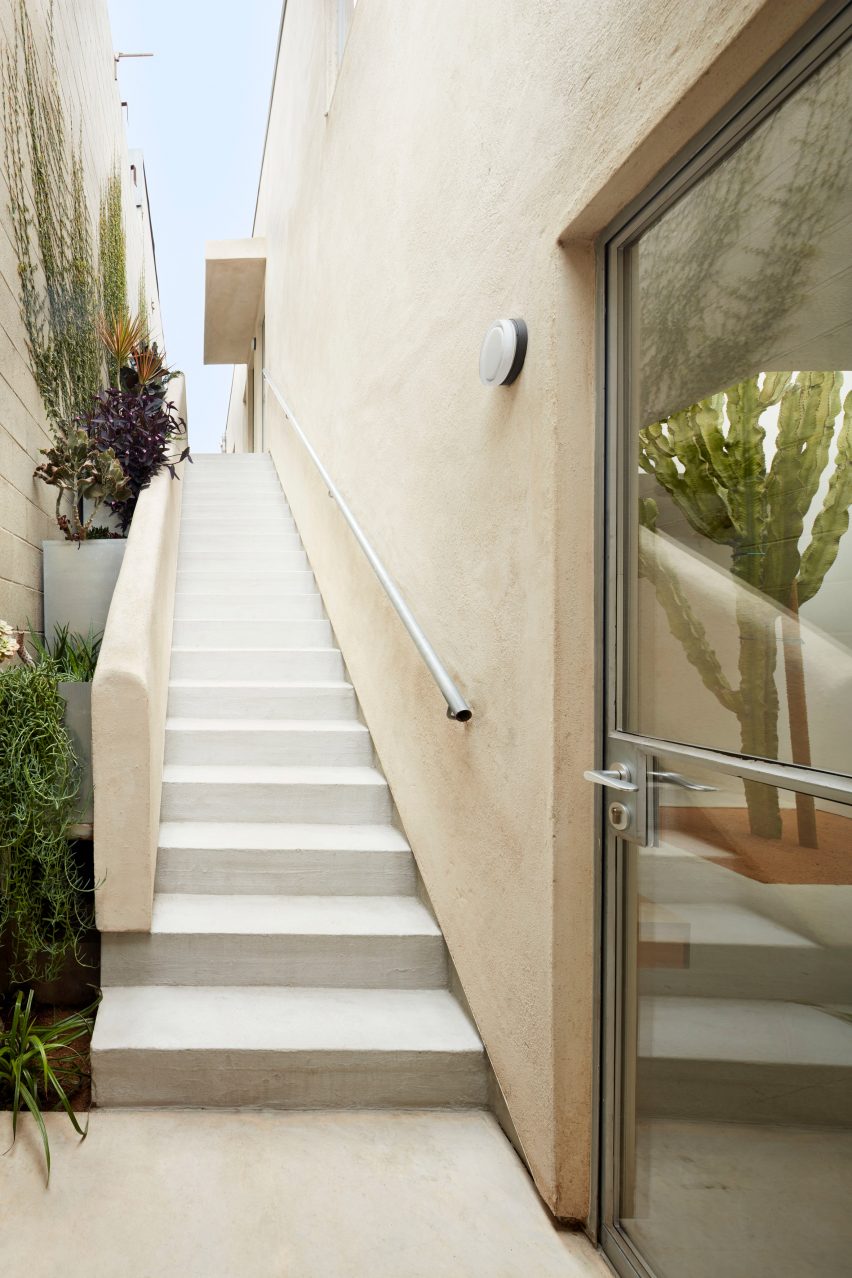 Exterior of Emeco House by David Saik with plaster walls, steel framed door and exterior staircase