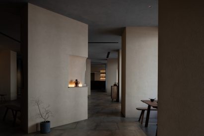 Angled beige stucco walls frame pathway through Jin Sheng Long restaurant in Qinhuangdao designed by Studio Nor