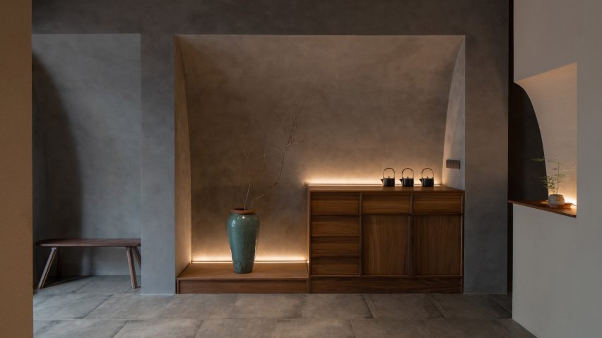 Entrance to Jin Sheng Long restaurant in Qinhuangdao designed by Studio Nor with curved niches carved into stucco-coated walls