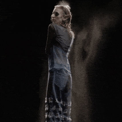 Holograms of a models at Maisie Wilen's AW22 fashion show spritzing herself with a water bottle