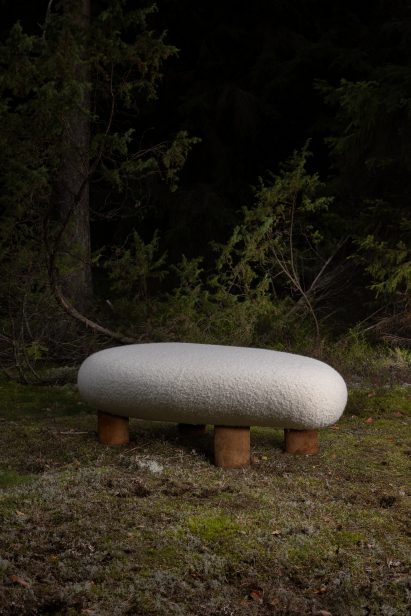 Bench with brown legs and woollen seat from Fomes seating collection in a forest