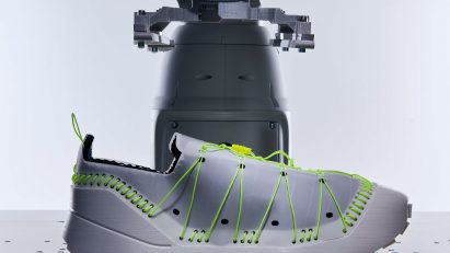 Grey trainer with fluorescent green lacing and stitches