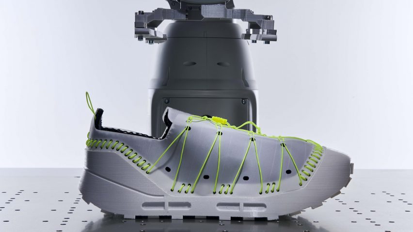 Grey trainer with fluorescent green lacing and stitches