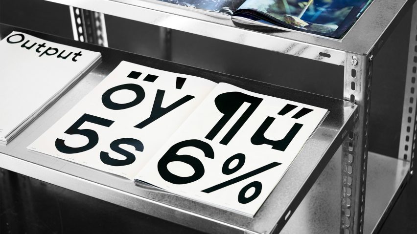 Magazine with large black type printed on white paper laid open on a metal table