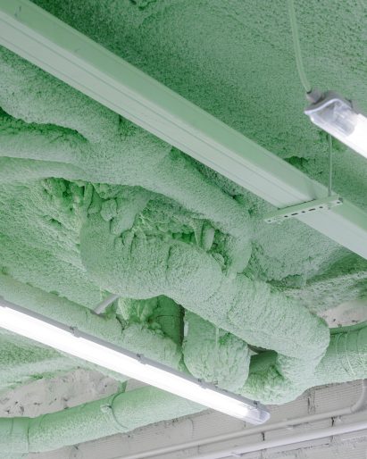 Green ceiling covered in insulation foam in interior by Casa Antillon