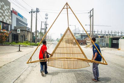 Two men carrying Waf Kiosk on a road