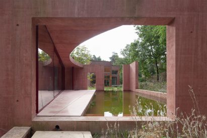 View of the Refuge swimming pond through a cut out in the pavillion wall