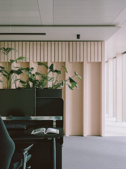 Desk banks with integrated planters in front of spruce partition in Samsung Design Europe office in London