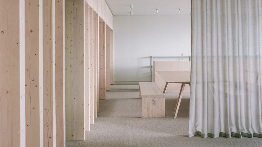 Spruce partitions and furniture next to grey linen curtain in office by McLaren Excell