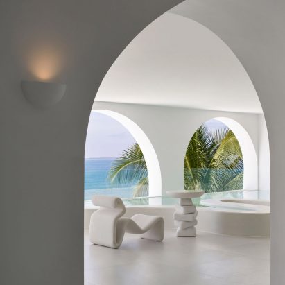 Sculptural white armchair and table in white room at Sumei Skyline Coast hotel by GS Design
