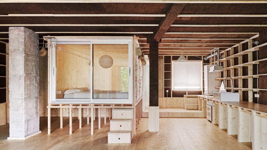Bedroom in a wooden box raised on stilts in a cork-clad apartment by Takk