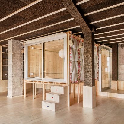Bedroom in a wooden box raised on stilts in a cork-clad apartment by Takk