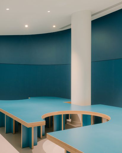 Teal-blue bench seating inside The Studio by h2o Architectes