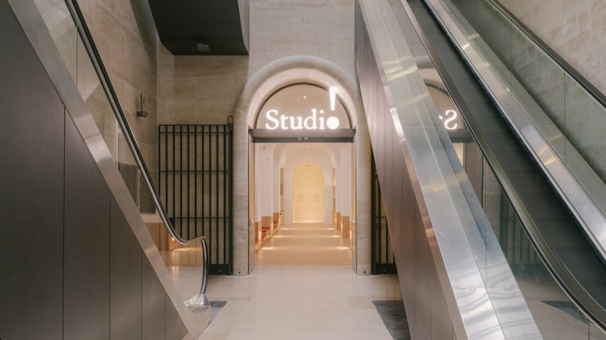 Entrance to The Studio at the Louvre museum illuminated by a neon sign