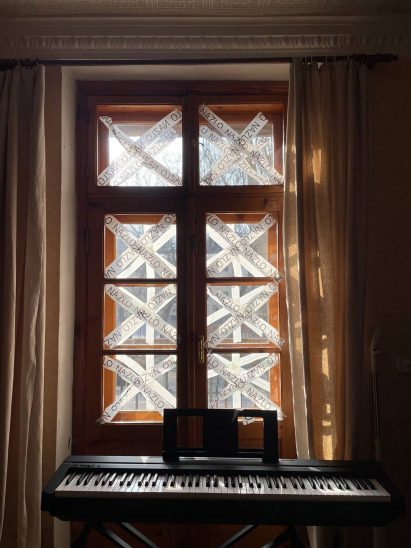 Tape over windows behind piano in apartment by designer from Sivak & Partners