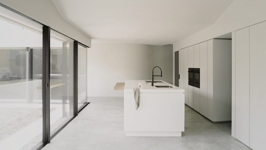 White coloured kitchen with a glazed wall