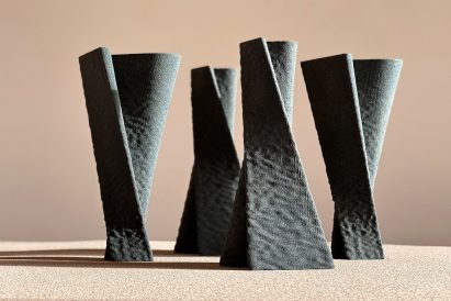 A photograph of the four sculptures that are 3D printed in grey quartz sand