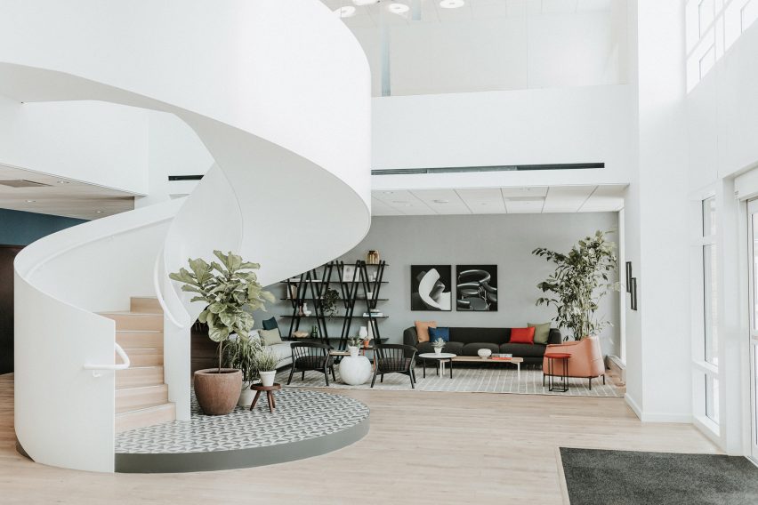 Photograph of a white and beige interior space with a curved stair on the left