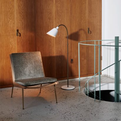 White Bellevue floor lamp set beside a lounge chair