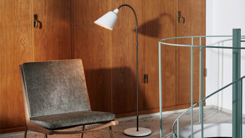 Bellevue lamp by &Tradition in white next to green railings and a lounge chair