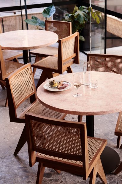 Marble tables and wicker-backed chairs