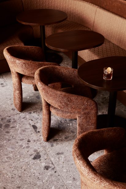 Upholstered chairs beside dark wood tables