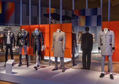 Standing Man is pictured among mannequins in tailoring