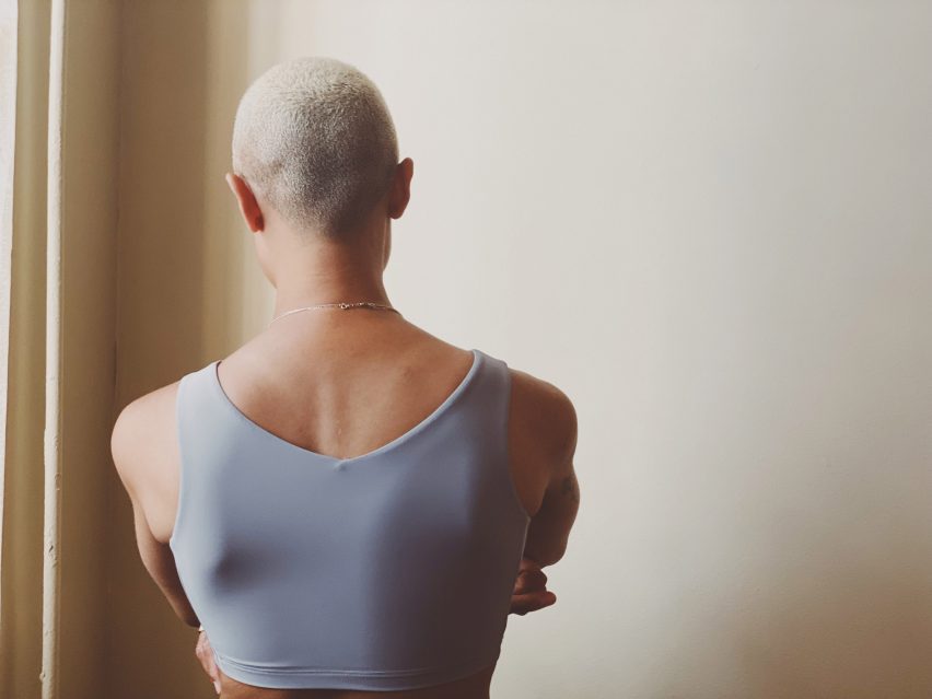 Person from the back wearing For Them's compressive chest binder in grey