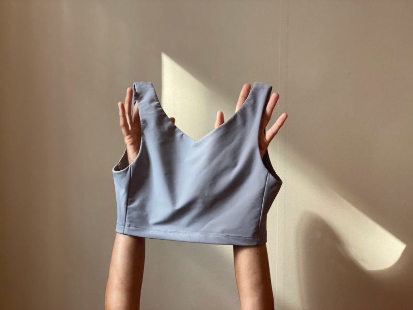 Pair of hands holds up For Them's binder in grey