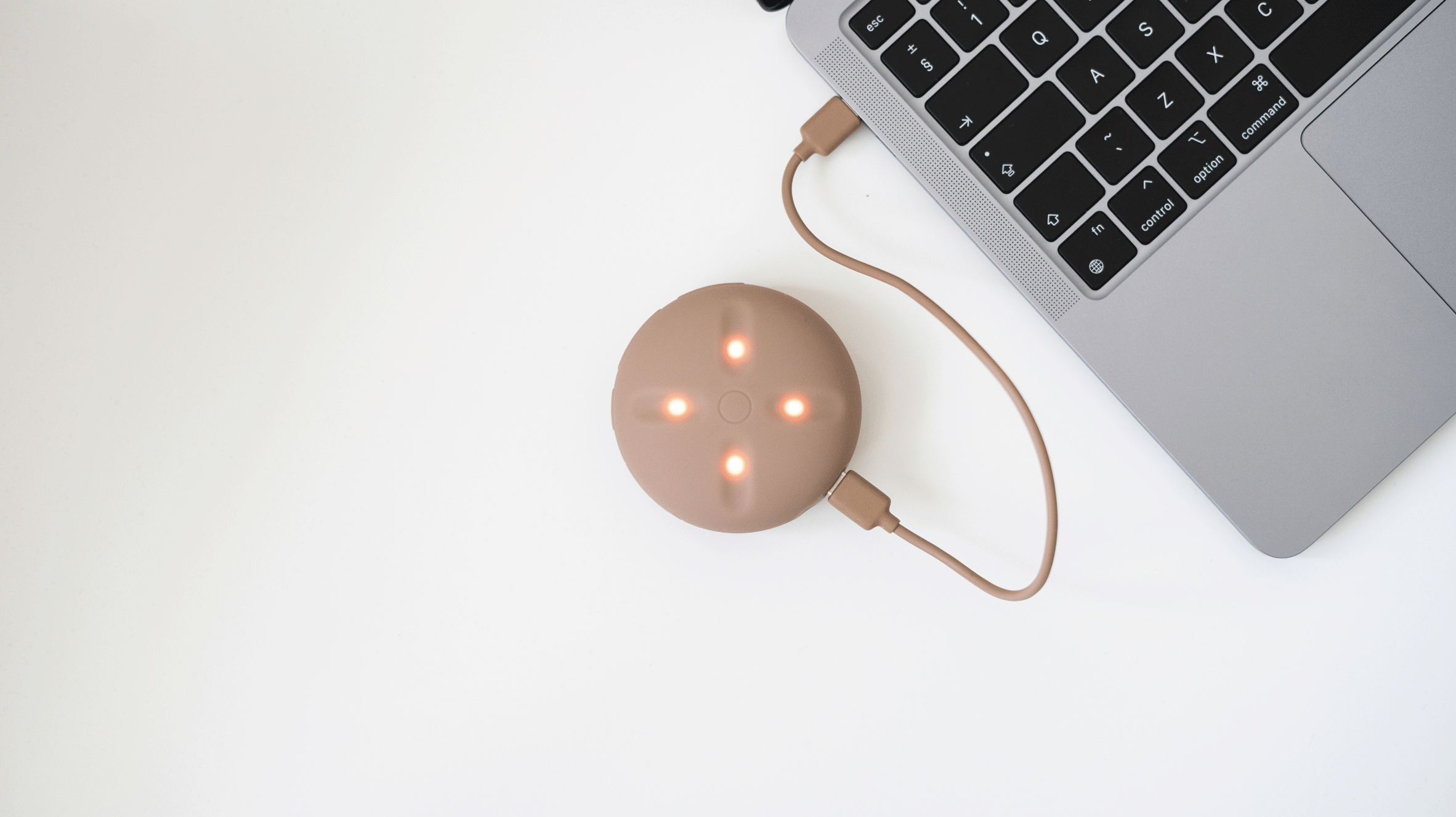 A beige device connected to a Mac laptop