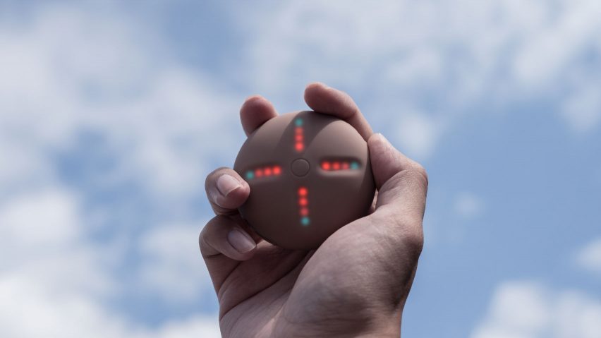 A hand holding a Stem Player against the sky