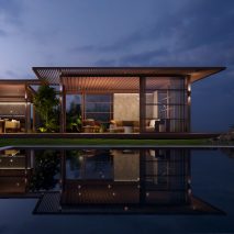 Pavilion H outdoor space by Kettal with ambient lighting at night and a pool in the foreground