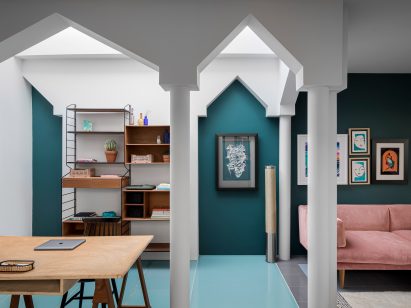 Study inside interior by Valentino Architects with petrol green walls and pointed archways