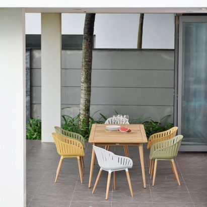 Multicoloured chairs from Nassau furniture collection by LifestyleGarden surrounding a wooden table