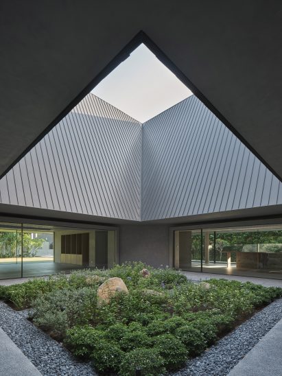 The squared garden sits below a large opening in the roof