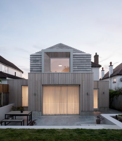Image of Hipped House from the rear that is lit from the inside