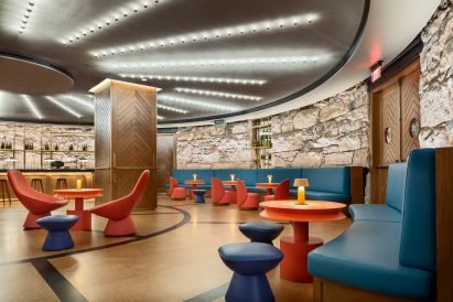 A public lounge area with blue sofas and orange seating