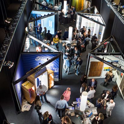 A photograph of people looking at the architect@work displays
