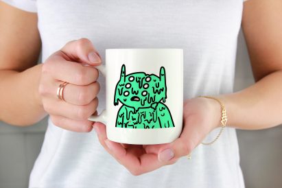 A photograph of an alien-like cartoon on a mug