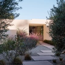 stucco home tucked in plants