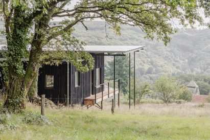 Image of the wooden house overlooking the rolling terrain
