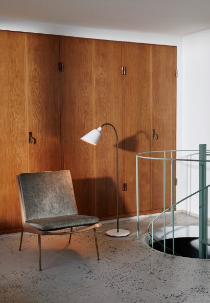 White Bellevue floor lamp by Arne Jacobsen for &Tradition next to a lounge chair