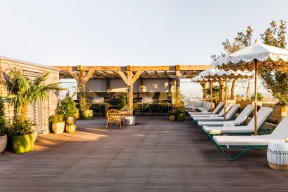 Roof terrace of apartment block by Way of Life and Fettle with sun loungers and beach-style umbrellas
