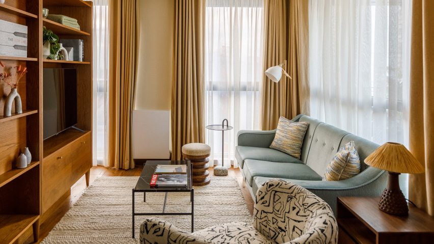 Guest suites inside The Gessner apartments by Way of Life and Fettle with light blue couch and wooden storage wall