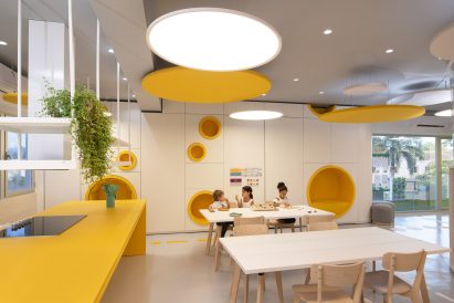 A yellow classroom with children at desks