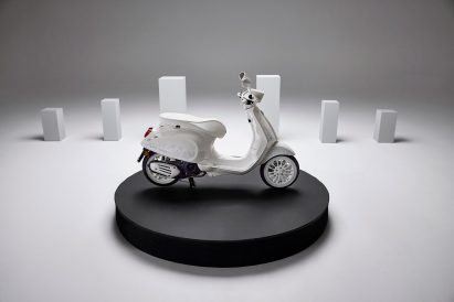 All-white Vespa on a circular black platform